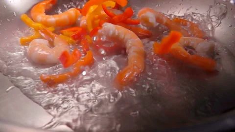 Close-up of large shrimps and red pepper falling in a hot oil Stock Footage 132167912