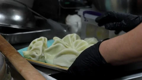 Close-up of large slotted spoon with cooked khinkali over large cauldron Stock Footage 267287787