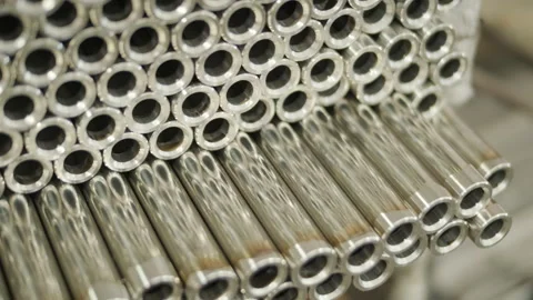 Close-up of a large stack of shiny, polished stainless steel metal tubes Stock Footage 345894285