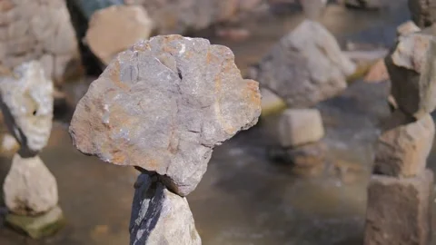 Close-up of a large stone balancing on a stone tower built on a mountain river. Stock Footage 169041820