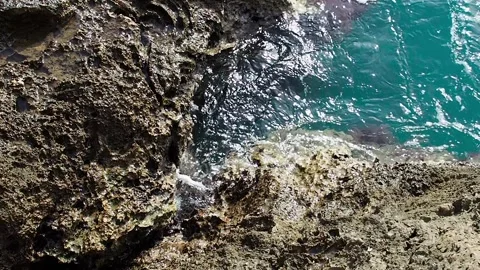 Close-up of a large stone in the sea. Stone beach. View from above. Waves crash Stock Footage 247501528
