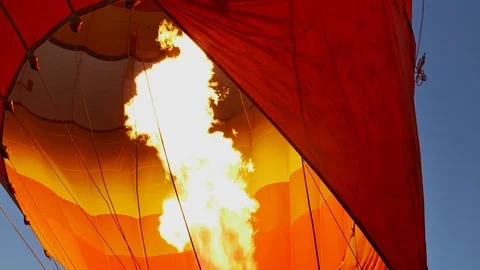 Close-up of a large yellow flame that blows from a burner into a balloon fabric. Stock Footage 105006946
