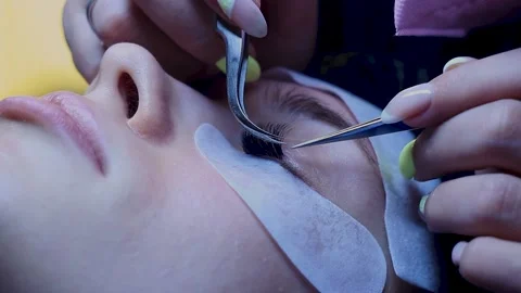 Close up. Lashes extentions procedure on white woman. Middle of procedure Stock Footage 150599617