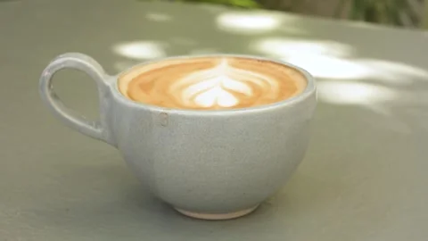 Close Up Latte Art Coffee in Ceramic Mug on Outdoor Table Stock Footage 341827082