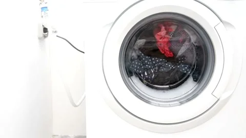 Close up laundry machine spinning washing clothing bubbling water house life Stock Footage 336589753