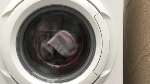 Close up laundry machine spinning washing clothing bubbling water house life Stock Footage 336594462