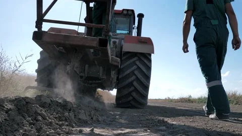 Close up. Lay the cable in the ground with a large wheeled tractor. Stock Footage 201509867