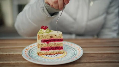 Close up of a layered sponge cake with cream and raspberry filling, topped with Stock Footage 332646536