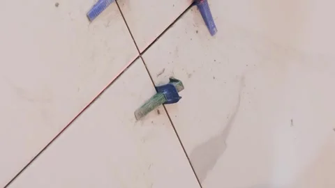 Close-up of laying ceramic tiles on the floor. Master builder installs tiles Stock Footage 250030125