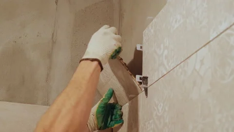 Close-up of Laying Ceramic Tiles on Wall. Professional Tiler Stick Tiles on Wall Stock Footage 145044973