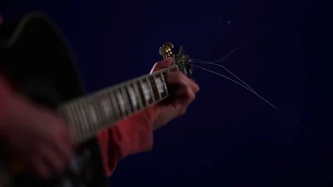 Close up Learning to play acoustic guitar on a dark background Stock Footage 80321336