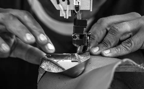 Close up of Leather sewing machine in action in a workshop with hands working Stock Photos