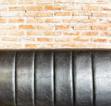 Close up Leather sofa at orange brick wall Stock Photos
