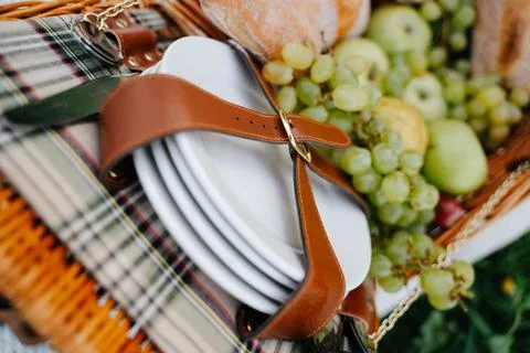 Close-up of a leather strap holding ceramic white picnic plates. Stockfoto's