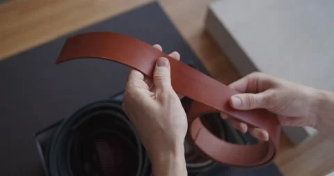 Close-up of leather worker hands examining leather blank for making a belt Video stock 146130831