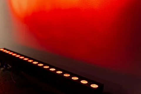 Close-up of LED stage light bar projecting strong red illumination on wall Stock Photos