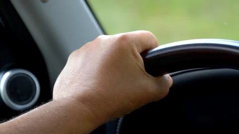 Close up of left man hand holding steering wheel and driving luxury car. Stock Footage 125057070