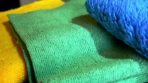 Close up left to right sliding shot of various microfiber towels in yellow Stock Footage 321071480