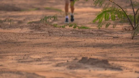 Close up leg of boy running on ground in rural on light of sunset background Stock Footage 129639007