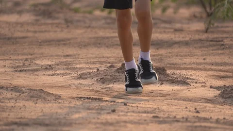 Close up leg of boy running on ground in rural on light of sunset background Stock Footage 129639172