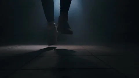 Close-up of a leg jumping rope in a dark room with back light  Stock Footage 274428937
