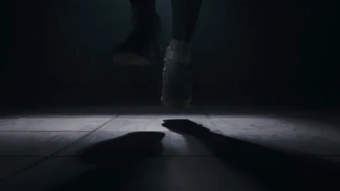 Close-up of a leg jumping rope in a dark room with back light  Stock-Footage 274429123