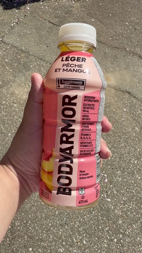 A close-up of a Léger Peach and Mango juice bottle held outdoor. 库存影片 333550770