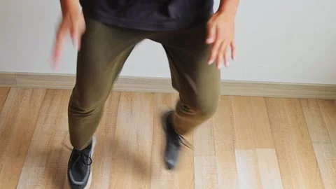 Close-up on legs and feet performing high knee taps exercise on wood flooring Stock Footage 345379745