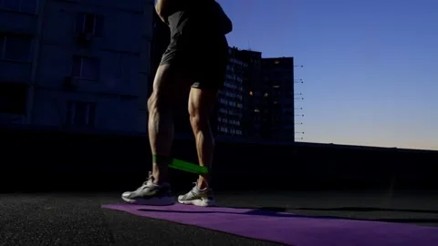 A close-up of the legs of an athlete performing an exercise with a fitness band. Stock Footage 252832153