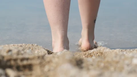 Close-up of legs on the beach Stock Footage 151387939
