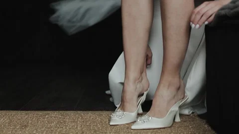 Close-up of the legs of a bride putting on her shoes and getting ready for her Stock Footage 308395980