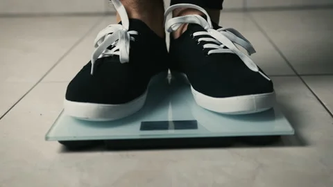 Close-up of legs getting on electronic weight and controlling their healthy Stock Footage 150039043