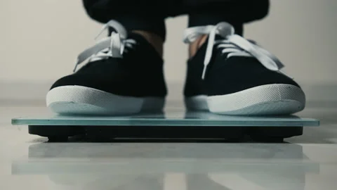 Close-up of legs getting on electronic weight and controlling their healthy Stock Footage 150043224