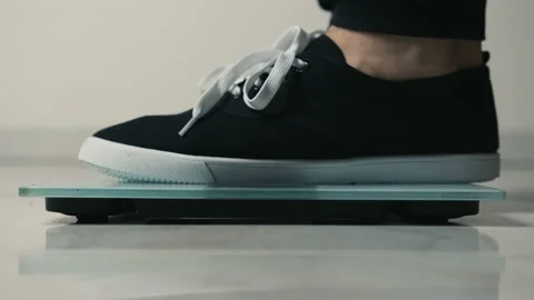 Close-up of legs getting on electronic weight and controlling their healthy Stock Footage 150260835