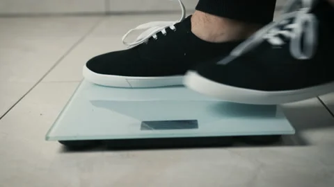 Close-up of legs getting on electronic weight and controlling their healthy Stock Footage 150513495
