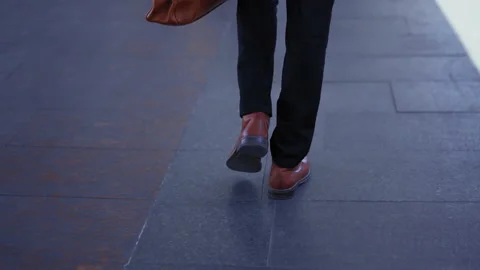 A close-up on the legs of a guy in a dolly suit is walking along the subway Video stock 131381409