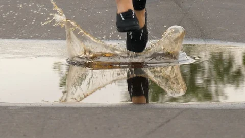 Close up legs jogger running and jump in water, slow motion Stock Footage 91545662