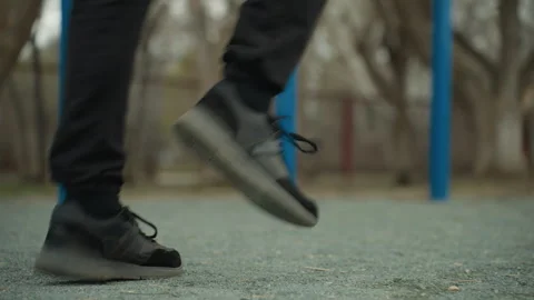 Close-Up of Legs Jogging Fast with Blurred Blue Iron Bars in Background Stock Footage 284469636