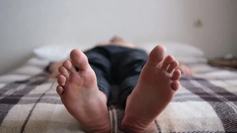 Close-up of the legs. The man is lying on his back. Selective focus. He scratche Stock Footage 147384163