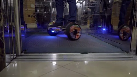 Close up of legs: a man riding on hoverboards into the elevator. Stock Footage 83489846