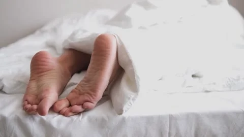 Close-up of the legs. A man sleeps on his stomach. Selective focus. He crossed h Stock Footage 147384243