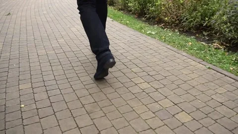 Close-up of legs of a man walking on a footpath Stock-Footage 142739139