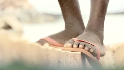 Close-up of the legs of a man who is building a boat with an ax. African Stock Footage 157785238