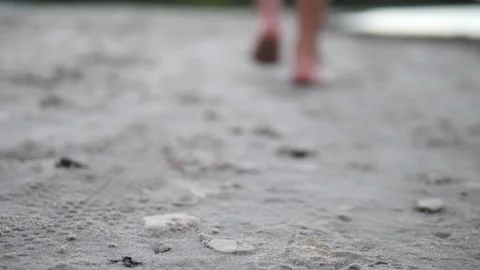A close-up of legs moving gracefully along beach covered in small pebbles, with Vidéo 282902753