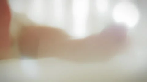 Close-up of the legs of newborn who is lying in his crib on a bright sunny d Stock Footage 263595558