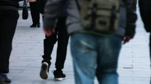 Close-up legs of pedestrians on sidewalk walking through street in winter Stock Footage 64882191