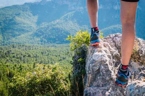 Close-up of legs of a runner with mountains in the background. Stock Photos