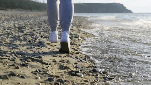 Close-up of the legs of a runner running along the beach and dodging the waves Stock Footage 169148218
