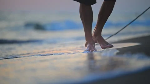 Close-up of legs strolling along the beach at golden hour, relaxing 4K footage. 库存影片 335422305