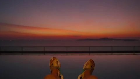 Close-up of legs in the swimming pool on the rooftop, sunset Stock Footage 223527828
